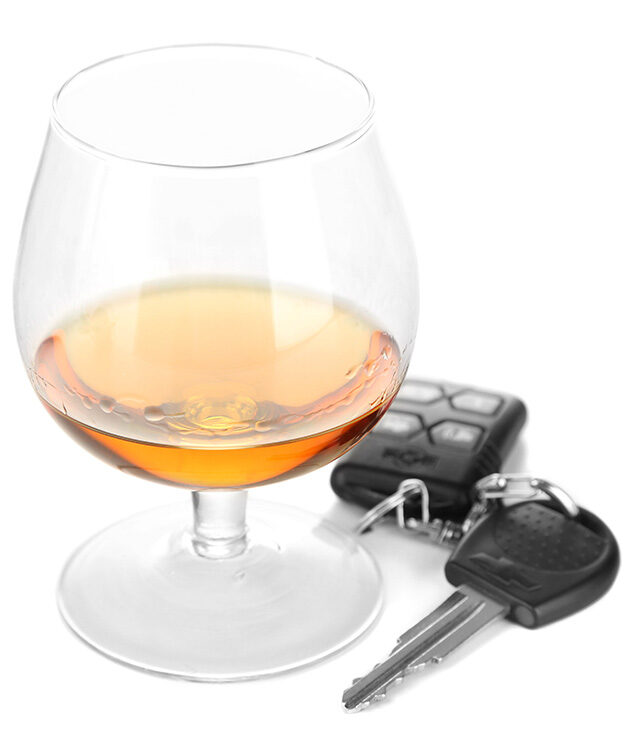 Alcoholic beverage in a glass next to car keys - DUI